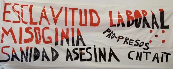 Pancarta de CNT-AIT Madrid denunciando la esclavitud laboral en prisiones, la misoginia y la sanidad asesina